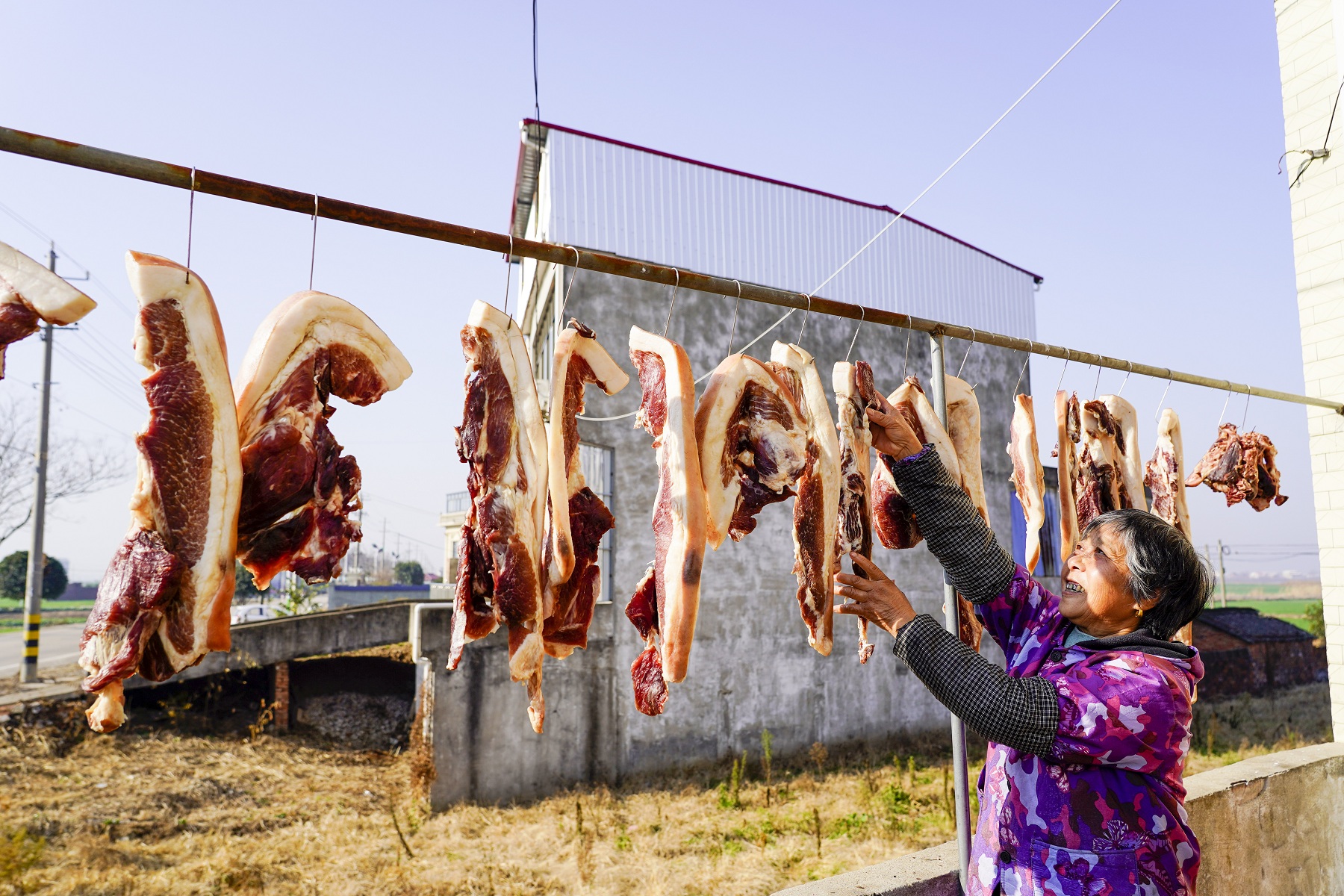 村民将腌制的猪肉晾晒在竹架上.jpg